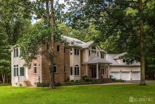 view of front of house featuring a garage, brick siding, aphalt driveway, and a front yard