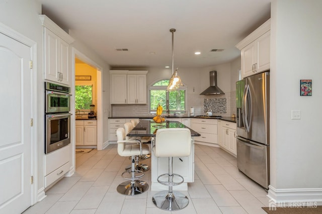 5 Ramapo Ct, Colts Neck, NJ 07722 - kitchen featuring stainless steel appliances, wall chimney exhaust hood, dark countertops, backsplash, and a kitchen breakfast bar