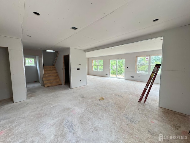 unfurnished living room with stairs