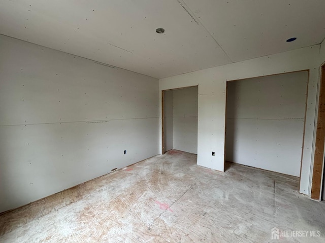 unfurnished bedroom featuring two closets