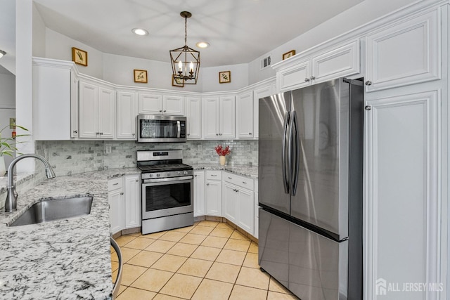 16 Exeter Pass, Colts Neck, NJ 07722 - kitchen featuring stainless steel appliances, white cabinetry, a chandelier, tasteful backsplash, and light tile patterned floors