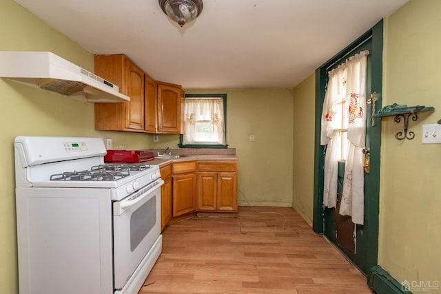 kitchen with white range with gas cooktop, sink, and light hardwood / wood-style floors