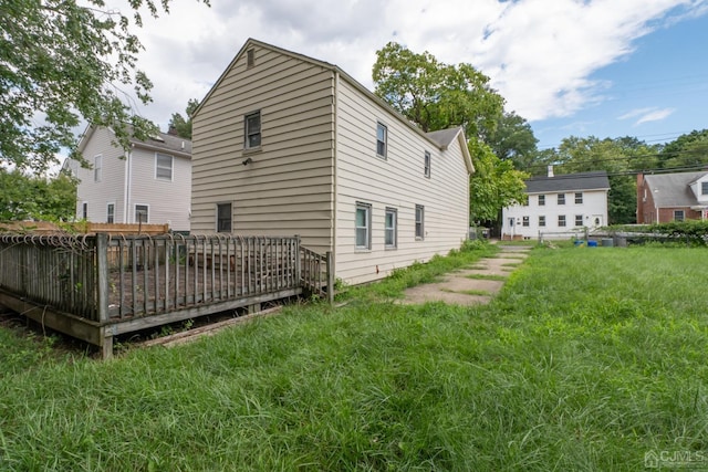 rear view of property with a deck and a lawn