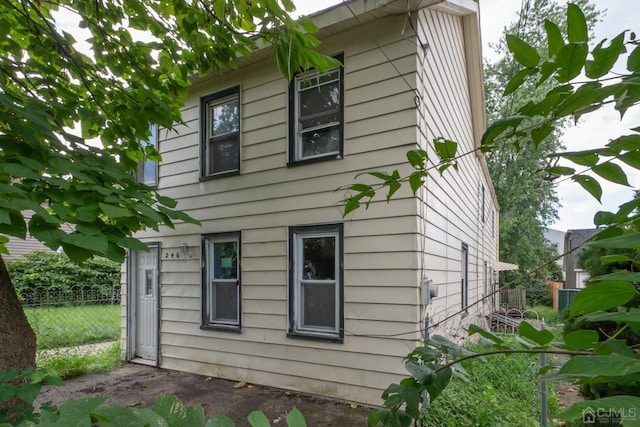 view of side of home featuring fence