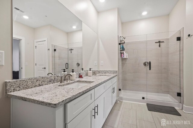 bathroom with a shower with door and vanity