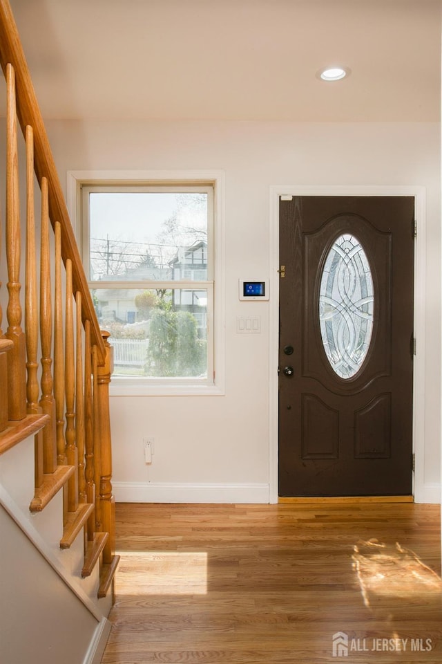 foyer entrance with recessed lighting, stairs, light wood-type flooring, and baseboards