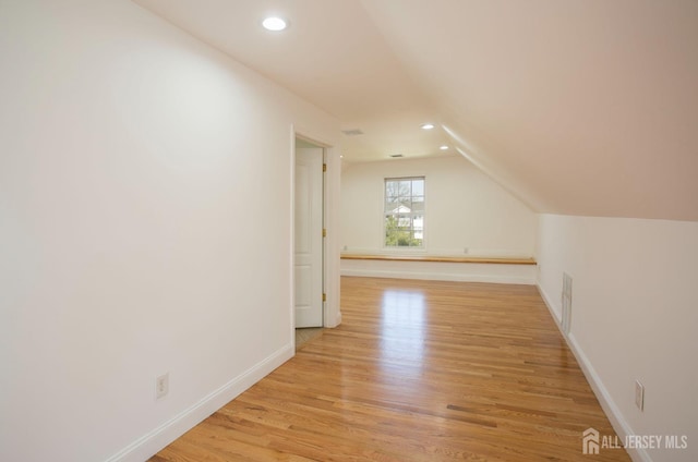 additional living space with recessed lighting, light wood-style floors, and baseboards