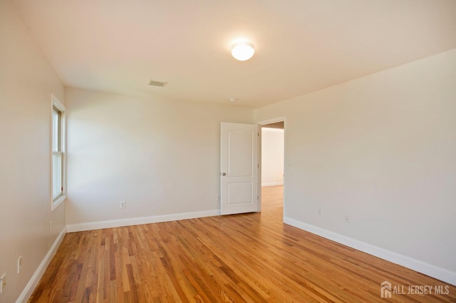 unfurnished room with visible vents, baseboards, and light wood-style floors