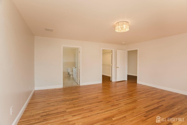 empty room featuring baseboards and light wood-type flooring