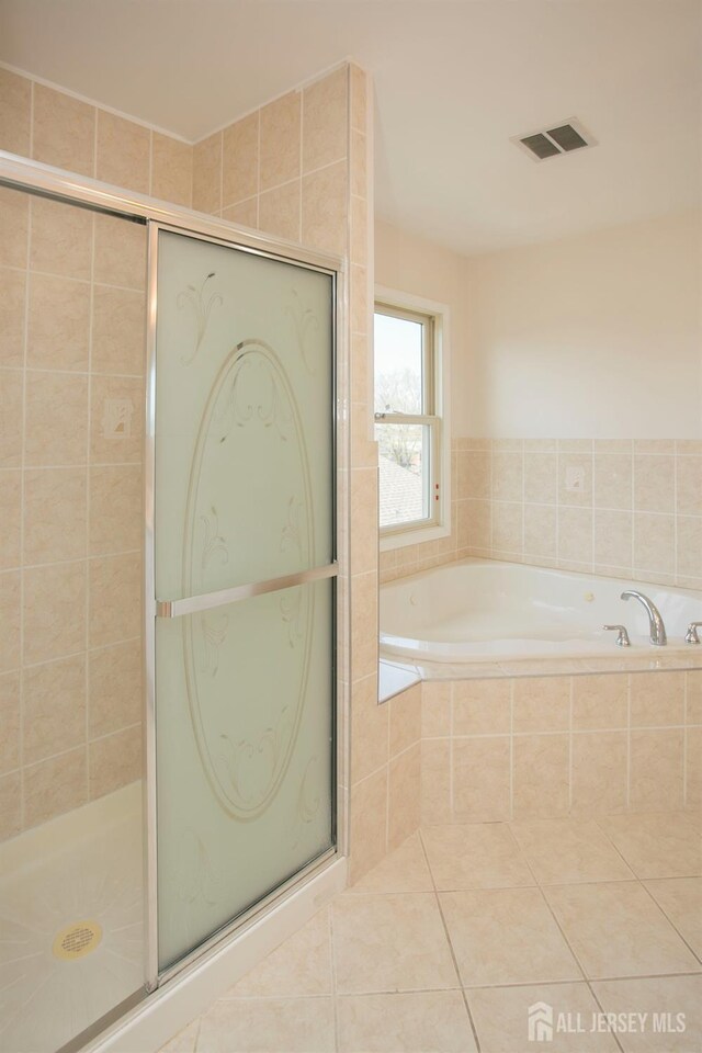 full bath featuring tile patterned floors, a shower stall, and a bath