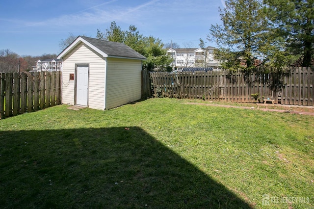 view of yard featuring a storage shed, a fenced backyard, and an outdoor structure