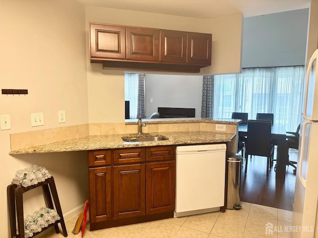 832 Edpas Rd, New Brunswick, NJ 08901 - kitchen with white appliances, a peninsula, light tile patterned floors, light stone counters, and healthy amount of natural light
