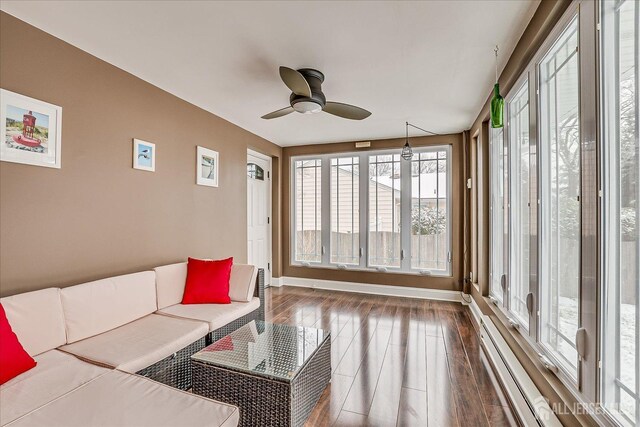 sunroom featuring ceiling fan and a baseboard heating unit