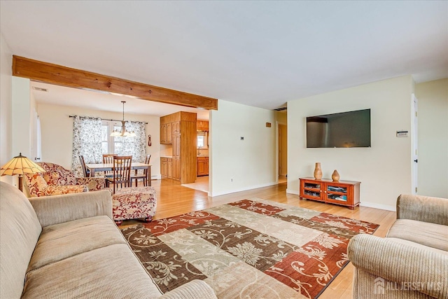 living room with a chandelier, beamed ceiling, and wood-type flooring