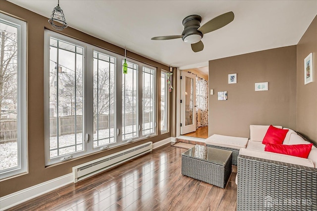 interior space featuring ceiling fan, a wealth of natural light, dark hardwood / wood-style floors, and a baseboard radiator