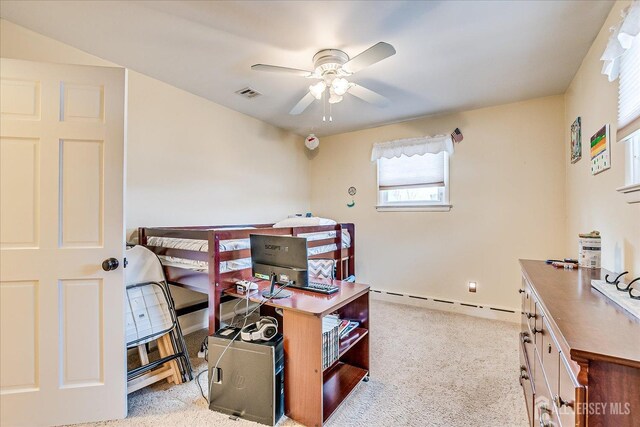 carpeted office space with ceiling fan and a baseboard heating unit