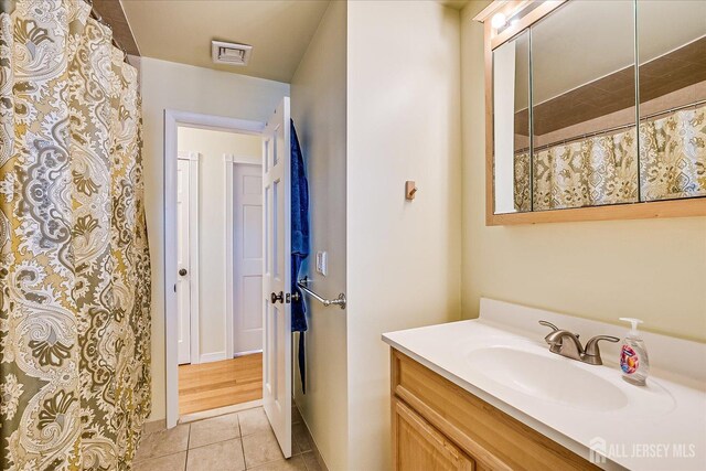 bathroom with vanity, a shower with curtain, and tile patterned flooring