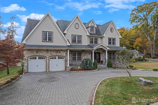 view of front of property with a front yard, a porch, and a garage