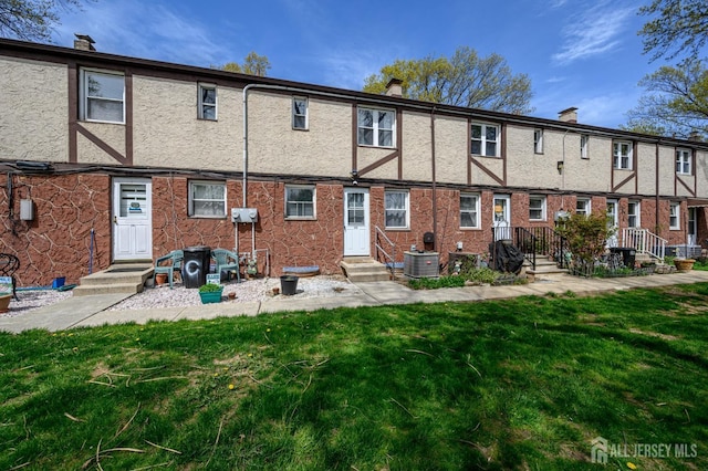 245 Newman St, Metuchen, NJ 08840 - back of house featuring a lawn, cooling unit, stucco siding, and a chimney