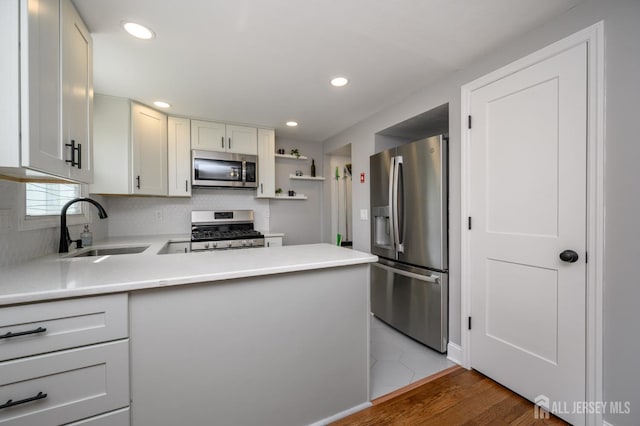 245 Newman St, Metuchen, NJ 08840 - kitchen featuring stainless steel appliances, a sink, light countertops, backsplash, and a peninsula
