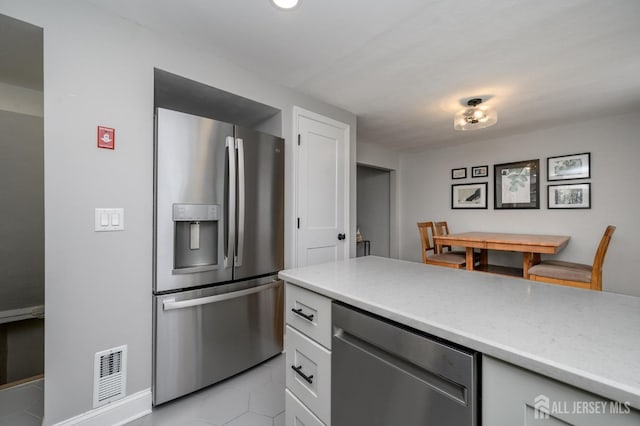 245 Newman St, Metuchen, NJ 08840 - kitchen featuring stainless steel appliances, light tile patterned floors, light countertops, and white cabinets