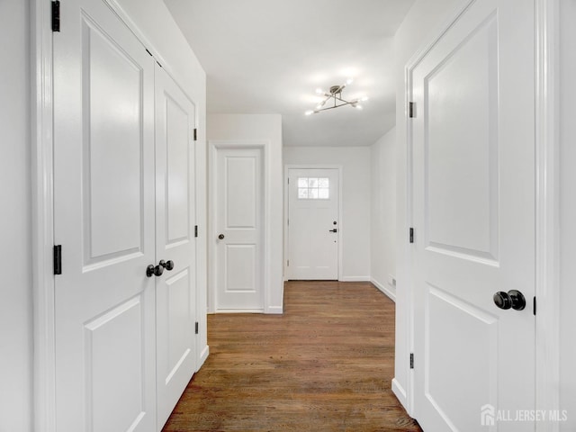 hall featuring a chandelier and hardwood / wood-style floors