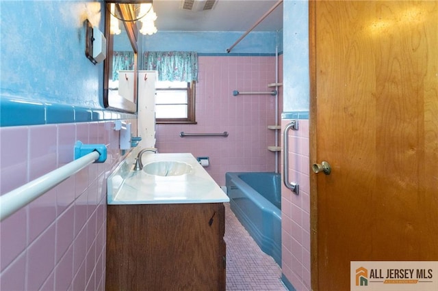 full bath with tile patterned floors, a wainscoted wall, tile walls, and vanity