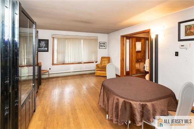 dining area featuring light wood finished floors and baseboard heating