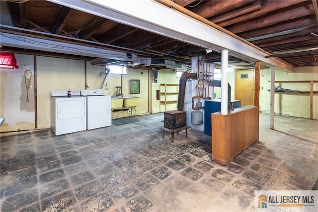 basement with washing machine and dryer and a wood stove