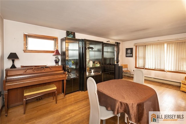 dining room featuring a baseboard radiator and wood finished floors