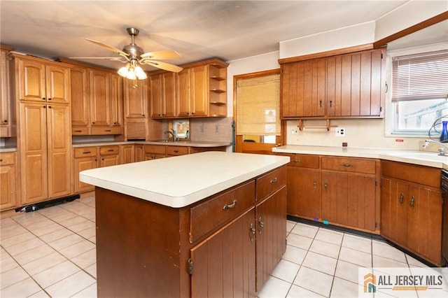 kitchen with open shelves, light countertops, light tile patterned flooring, a kitchen island, and a sink