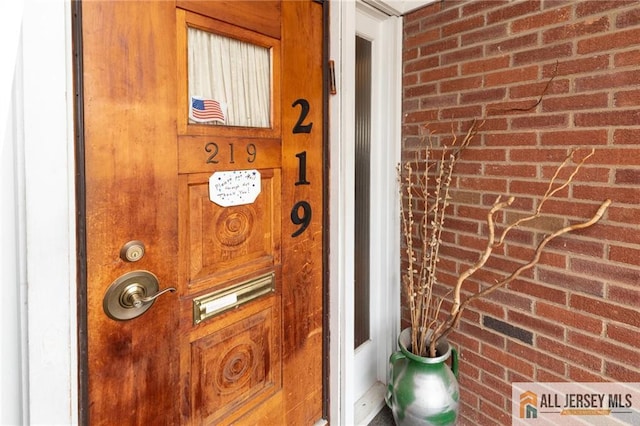 doorway to property featuring brick siding