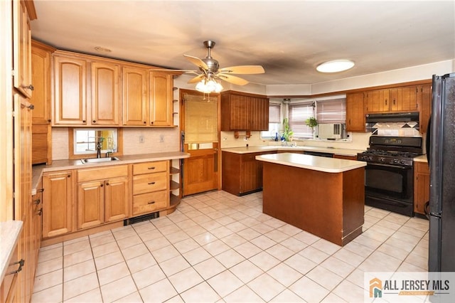 kitchen featuring ceiling fan, under cabinet range hood, a sink, light countertops, and black appliances