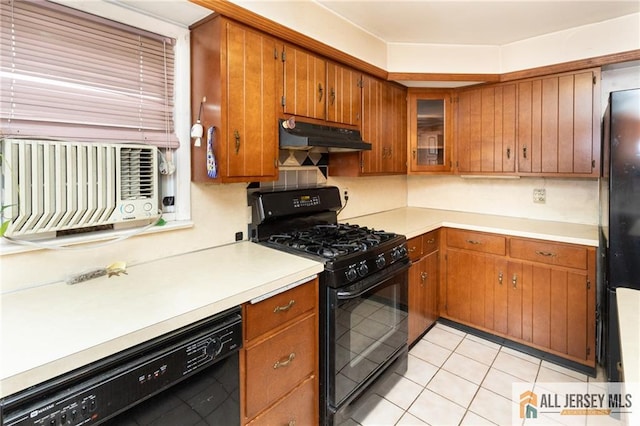 kitchen featuring light tile patterned floors, under cabinet range hood, light countertops, brown cabinets, and black appliances