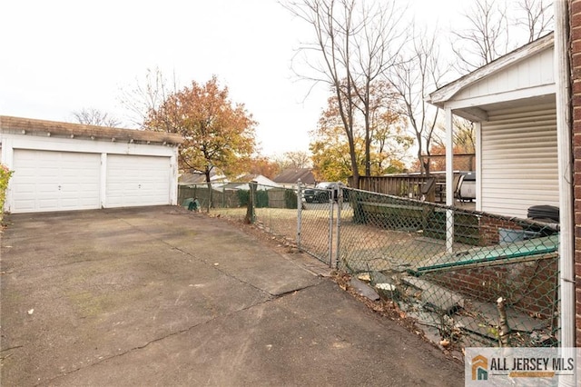 view of yard with a garage, an outdoor structure, fence, and a gate