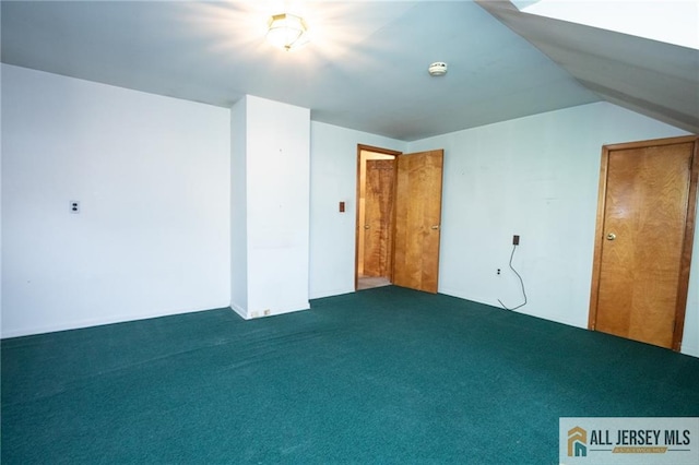 bonus room with vaulted ceiling and dark colored carpet