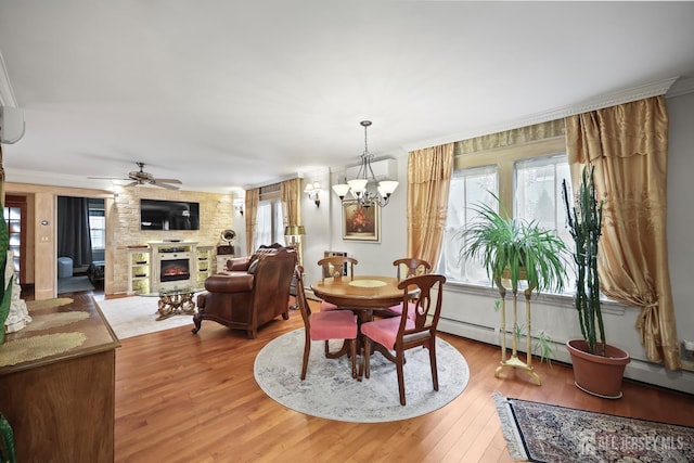 365 E John St, South Amboy, NJ 08879 - dining area with a lit fireplace, light wood-style flooring, ornamental molding, a chandelier, and a ceiling fan