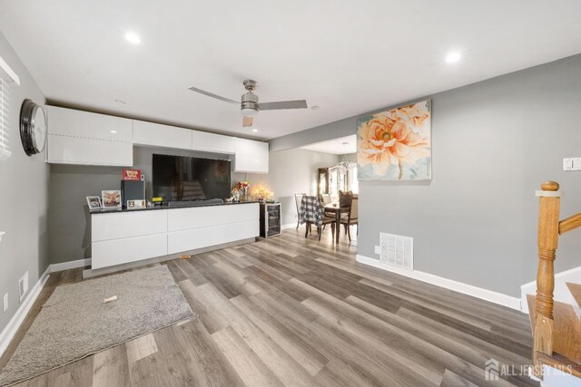 unfurnished living room featuring ceiling fan and hardwood / wood-style floors