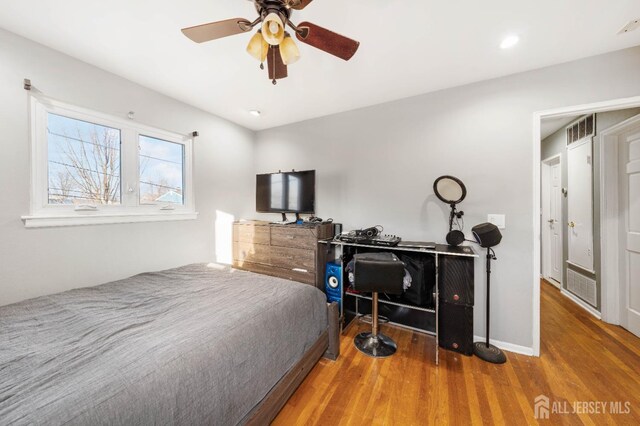 bedroom with wood-type flooring and ceiling fan