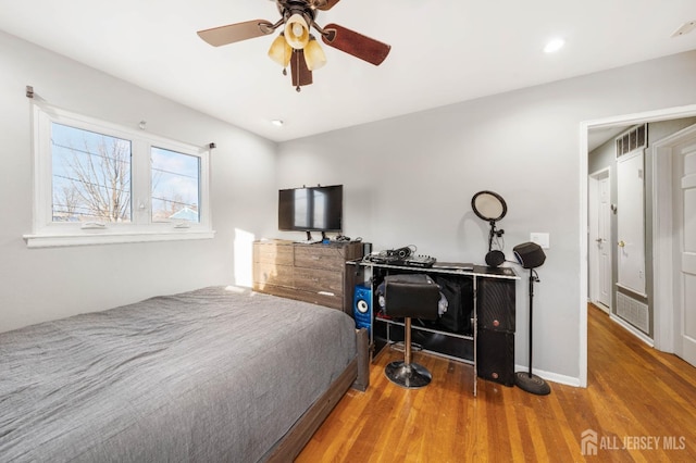 bedroom with ceiling fan and hardwood / wood-style floors