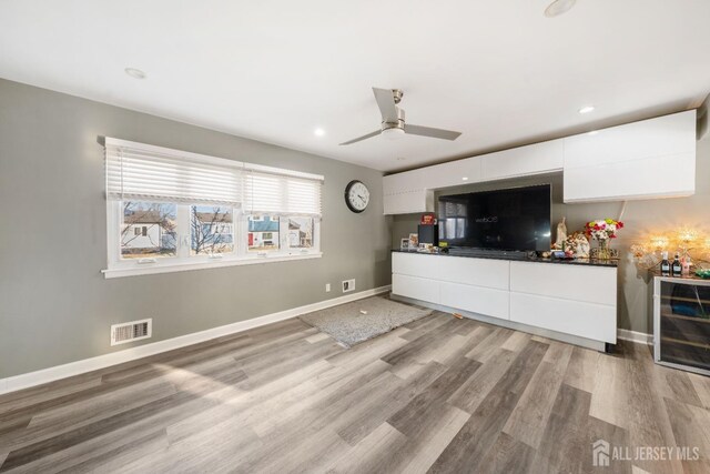 unfurnished living room featuring ceiling fan and light wood-type flooring