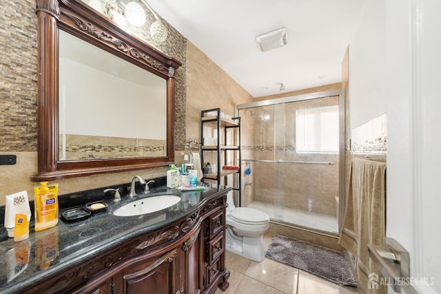 bathroom featuring vanity, tile patterned flooring, a shower with door, and toilet