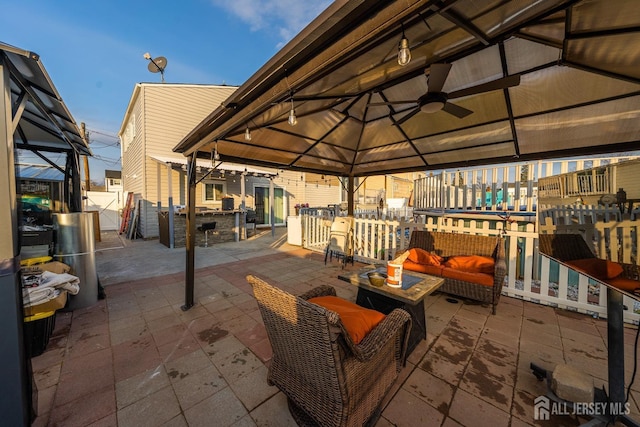 view of patio / terrace with an outdoor living space, a gazebo, and ceiling fan