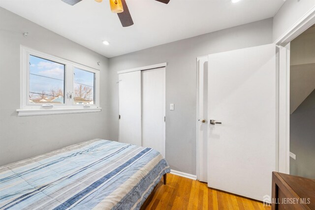 bedroom featuring hardwood / wood-style floors, ceiling fan, and a closet