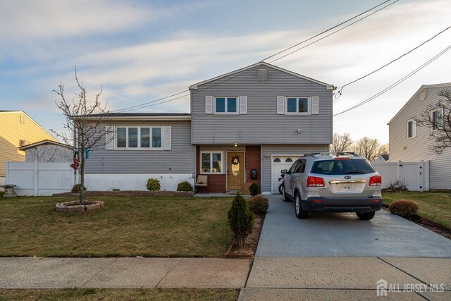 tri-level home with a garage and a front yard