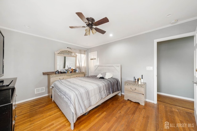 bedroom with hardwood / wood-style flooring, ceiling fan, and ornamental molding