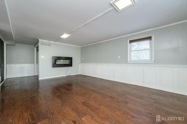 spare room with ornamental molding and dark hardwood / wood-style flooring