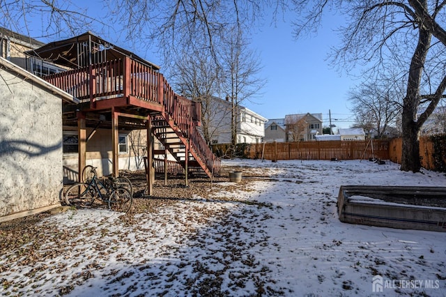 yard layered in snow with a wooden deck