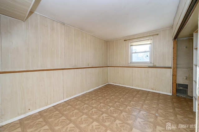 basement with wooden walls and light parquet floors