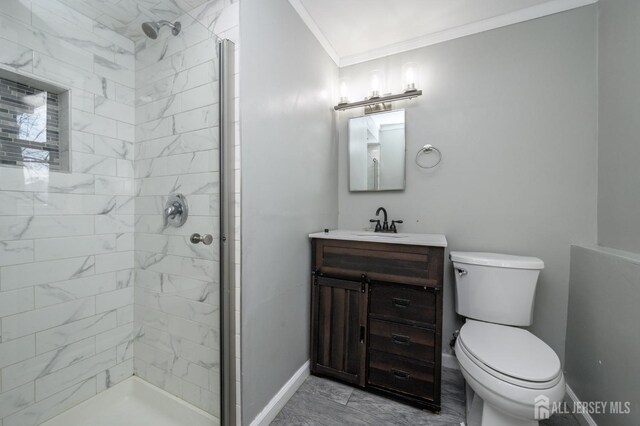 bathroom with crown molding, vanity, toilet, and a tile shower